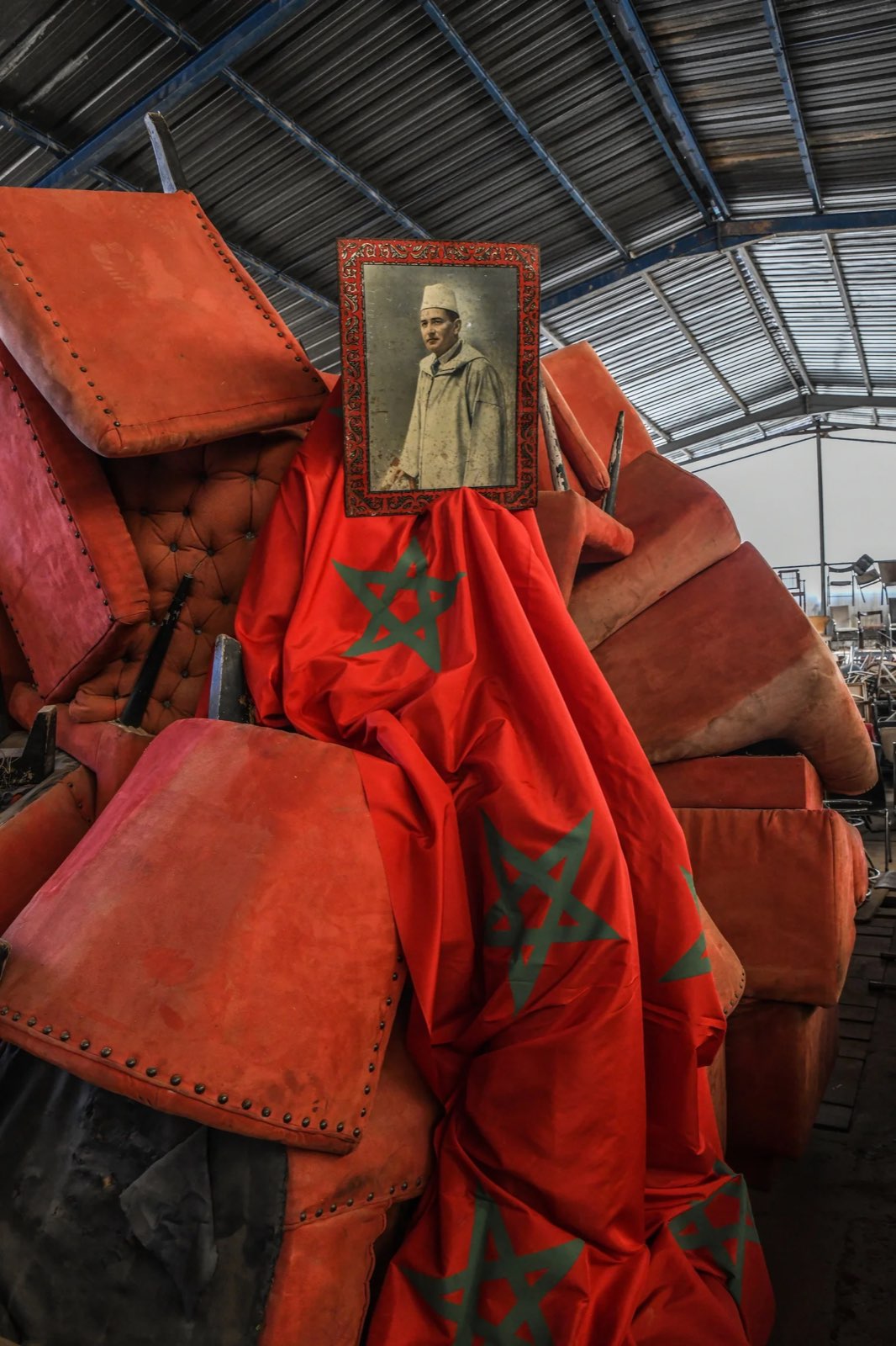 A framed portrait and the Moroccan flag draped over stacked red velvet — the heritage Maison ARTC is made from.